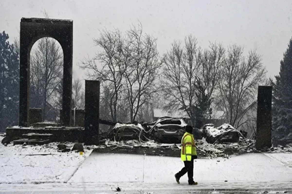 A worker walks past a destroyed home in Louisville, Colorado, on Friday, 31 December 2021.