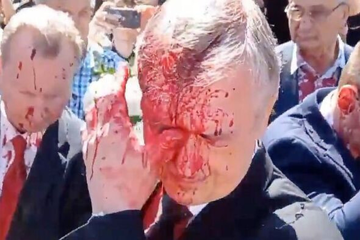 Russian Ambassador doused in blood red paint as protesters crowd him in Poland